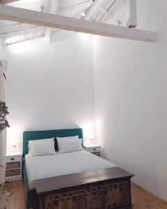 a bedroom with a bed with a wooden table at Totolos home in Lazaratika Corfu in Áyios Pandeleḯmon