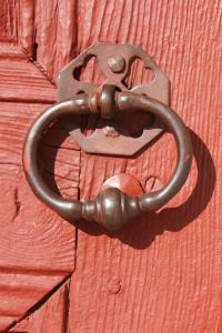 un candado de metal en una puerta de madera roja en Gîte Camporells, en Dorres