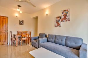 a living room with a couch and a table at Greenfinch Apartment in Baga