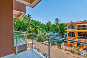una imagen de un balcón de una casa con palmeras en Greenfinch Apartment en Baga