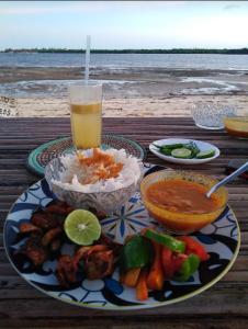 a table with a plate of food and a drink at Subira Guest House and Restaurant in Lamu
