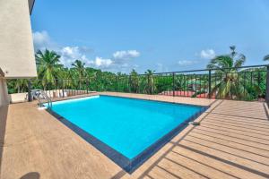 a swimming pool on the deck of a house at Greenfinch Apartment in Baga