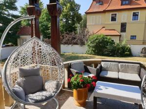 a swing on a patio with a bench and flowers at PAŁACYK BUDGET in Legnica