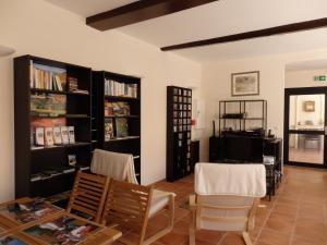 sala de estar con sillas, mesa y estanterías en Le Merlanson chambres d'hôtes, en Bez-et-Esparon