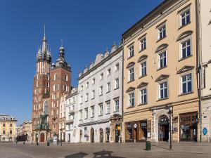 a group of buildings on a street with a clock tower at Apartament Rynek Główny 7 in Krakow