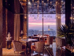 卡薩布蘭卡的住宿－卡薩布蘭卡曼蘇爾皇家酒店，一间设有桌椅的餐厅,享有城市美景