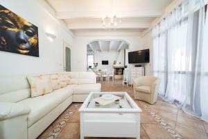 a living room with a white couch and a table at Villa Geraldina con piscina in Torre Suda