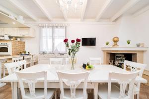 a kitchen and dining room with a white table and chairs at Villa Geraldina con piscina in Torre Suda