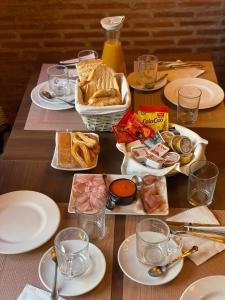 a wooden table with plates of food on it at Hostal El Descanso Del Emperador in Jarandilla de la Vera