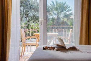 a room with a bed with a book and glasses at Quinta Bonita Country House & Gardens in Lagos