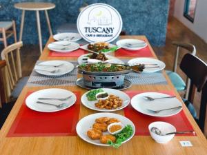 una mesa con platos de comida encima en Tuscany Hotel Buriram en Buriram