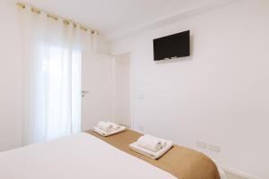 a white bedroom with a bed with towels on it at Marisabella Suite Spa 3 in Bari +27 photos