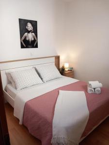 a bedroom with a large bed with a picture on the wall at Apartments Pipi in Pakoštane