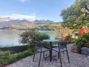two chairs and a table with a view of a lake at Best of Lake Site in Spiez