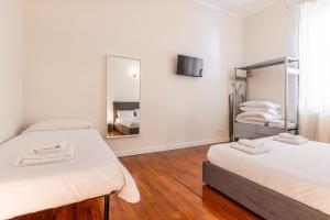 - une chambre avec 2 lits et un miroir dans l'établissement Cortivo House - Silva 45 next to metro Lotto, à Milan