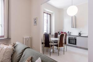 - une cuisine et une salle à manger avec une table et des chaises dans l'établissement Cortivo House - Silva 45 next to metro Lotto, à Milan