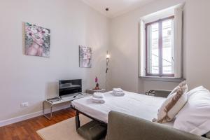 Cette chambre blanche dispose d'un lit et d'un canapé. dans l'établissement Cortivo House - Silva 45 next to metro Lotto, à Milan