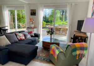 a living room with a couch and a table at Le Moulin de Bury, Maison de campagne au bord de la rivière à 13 kms au Sud de Rennes in Chavagne