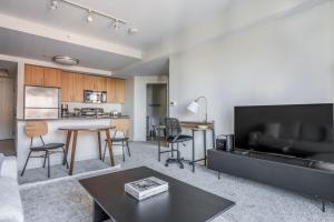 a living room with a table and a kitchen at East Cambridge 1br w gym wd near T stop BOS-959 in Boston