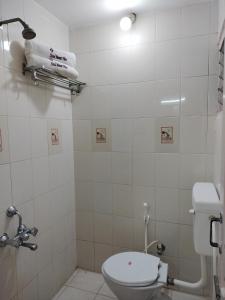 Baño con aseo y toalla en la pared en Hotel Mount View, en Kodaikanal