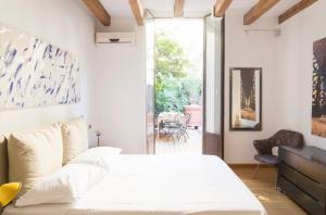 a bedroom with a white bed and a patio at Palm Fronds in Milan