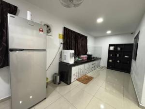 a kitchen with a refrigerator and a counter in it at 126 Homestay TYPE B in Tangkak +12 photos