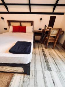 1 dormitorio con cama, mesa y escritorio en Roy's Villa en Sigiriya
