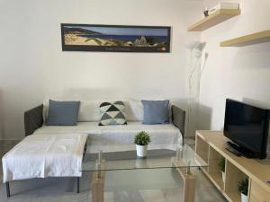 uma sala de estar com um sofá e uma televisão em Apartamento Buenaventura em Chiclana de la Frontera