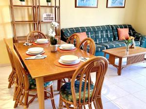 mesa de comedor con sillas y sofá en APARTBEACH MAR INTERNUM 4 JUNTO PLAYA y PISCINA en La Pineda