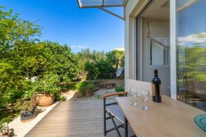 a wooden table with wine glasses on a patio at The Holiday House 1 in Kavrokhórion