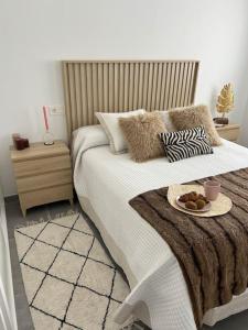 Un dormitorio con una cama con un plato de comida. en Sol, playa y relax en Fuengirola en Fuengirola