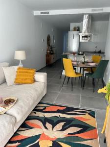 a living room with a couch and a table with yellow chairs at Sol, playa y relax en Fuengirola in Fuengirola