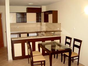 a kitchen with a table and chairs and a counter at Sun Palace Home Apartments in Sunny Beach