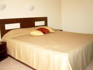 een slaapkamer met een groot bed met een houten hoofdeinde bij Sun Palace Home Apartments in Sunny Beach