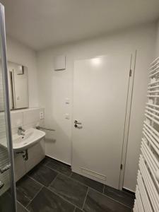 a bathroom with a white door and a sink at State of the Art in Nuremberg