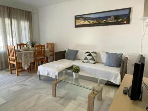 uma sala de estar com um sofá e uma mesa em Apartamento Buenaventura em Chiclana de la Frontera