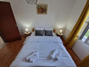 1 dormitorio con 1 cama blanca grande y 2 almohadas en Apartman Irvas Kolasin, en Kolašin