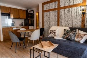 Il comprend un salon avec un canapé bleu et une cuisine. dans l'établissement Résidence Cami Réal ****, à Saint-Lary-Soulan