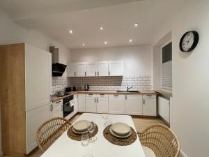a kitchen with a table and chairs and a clock at Stadtjuwel: Zentral & Modern in Lichtenfels +6 photos