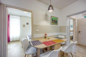 comedor con mesa de madera y sillas blancas en Apartments Jantar - Happy Rentals en Novo Mesto