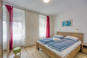 a bedroom with a bed and a green chair at Apartments Jantar - Happy Rentals in Novo Mesto