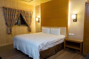 een slaapkamer met een groot bed en een raam bij Dragon Manor Resort in Renai