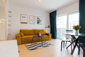 a living room with a yellow couch and a table at ShortStayPoland Szwedzka (B71) in Warsaw