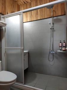 een badkamer met een douche en een toilet bij Dragon Manor Resort in Renai