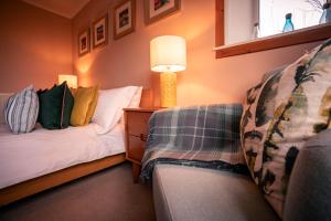 a room with two beds and a lamp on a table at Pabbay House Self Catering in Back