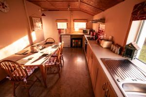 a kitchen with a table and chairs in it at Pabbay House Self Catering in Back