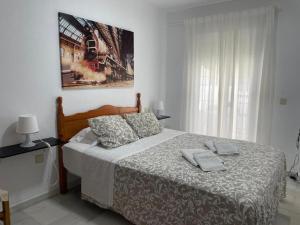um quarto com uma cama e uma fotografia na parede em Apartamento Buenaventura em Chiclana de la Frontera