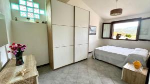 Schlafzimmer mit einem Bett und einem Fenster in der Unterkunft appartamento la Pila in Marina di Campo