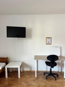 een witte kamer met een bureau en een stoel bij Apartmán Simmy in Modřice