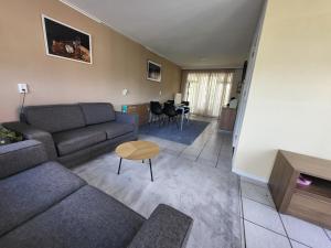 a living room with a couch and a table at vakantie appartement Stadskanaal in Stadskanaal